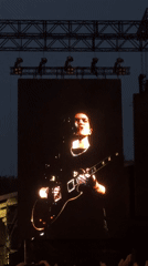 Male musician performs on outdoor concert screen in Paris
