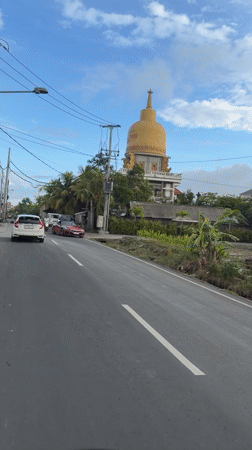 Traffic flows past golden-domed building in Mengwi, Indonesia
