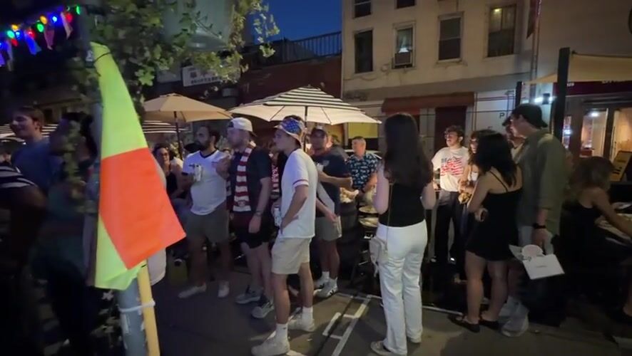 Late-night outdoor gathering features patriotic attire in New York