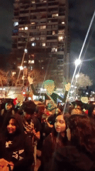 Nighttime crowd in Providencia carries oversized political figure cutout