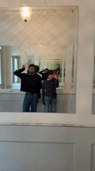 Two people photographed in mirrored reflections in Berlin hallway
