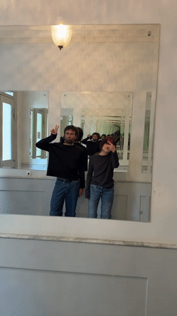 Two people photographed in mirrored reflections in Berlin hallway