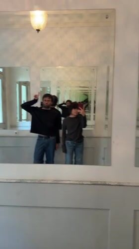 Two people photographed in mirrored reflections in Berlin hallway