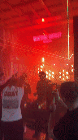 DJ set and dancing at a dimly lit rustic indoor venue