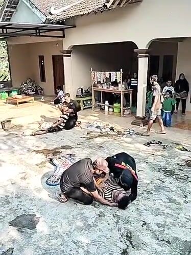 Outdoor courtyard scene with people on the ground in Mojogedang