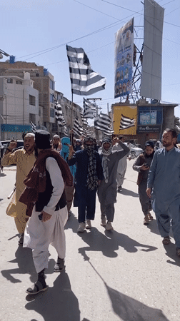 Political procession with striped flags marches through Quetta streets