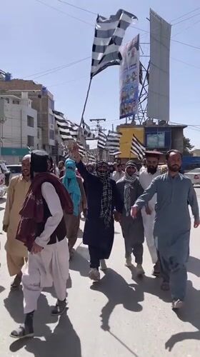 Political procession with striped flags marches through Quetta streets