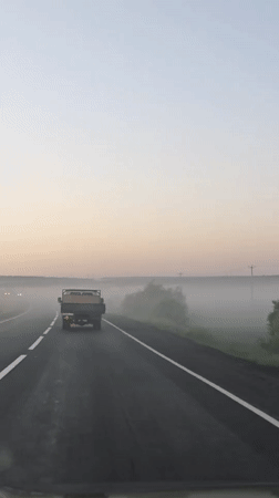 Truck travels foggy dawn road in Izhevsk, Russia