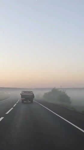 Truck travels foggy dawn road in Izhevsk, Russia