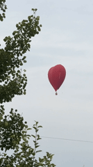 Heart-shaped hot air balloon floats over Dmitrov on a cloudy afternoon