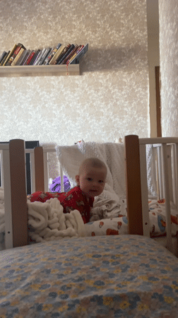 Baby in red pajamas observed in crib in Sochi