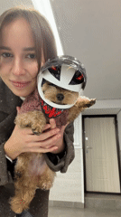 Woman poses with dressed-up dog in Moscow home