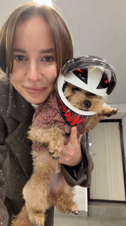 Woman poses with dressed-up dog in Moscow home