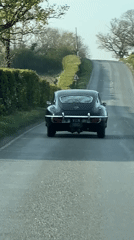 Classic car travels uphill road in East Suffolk