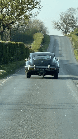 Classic car travels uphill road in East Suffolk