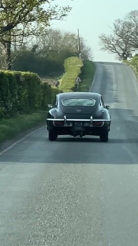 Classic car travels uphill road in East Suffolk