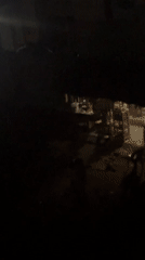 Nighttime gathering of residents on street corner in Ihiagwa