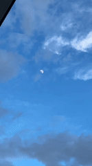 Daytime crescent moon over Nha Trang, with a nail close-up