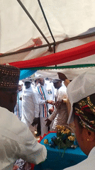 Crowd gathers under decorated tent for daytime event