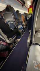 Crew member walks aircraft aisle during flight operations