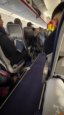 Crew member walks aircraft aisle during flight operations