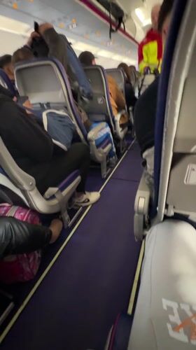 Crew member walks aircraft aisle during flight operations