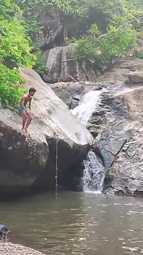 Young People Cliff Jump at Thailand Waterfall During Morning Recreation