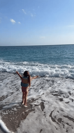 Children play on sunny Fethiye beach, enter turquoise waters
