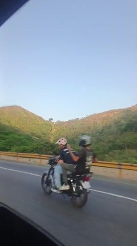 Black pickup truck filmed on Venezuelan roadway near hills