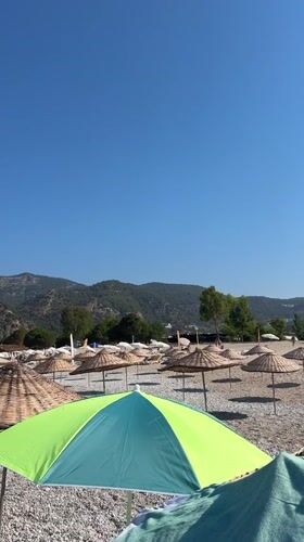 Paragliders and beach umbrellas on a sunny Fethiye morning