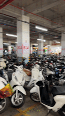 Woman takes selfie in crowded Vietnamese motorcycle parking garage