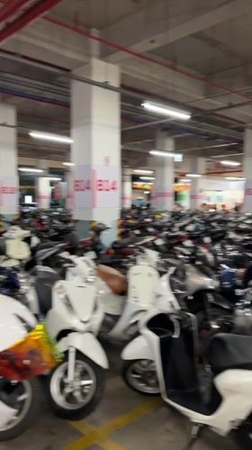 Woman takes selfie in crowded Vietnamese motorcycle parking garage