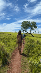 Woman walks barefoot on dirt path in Dapa