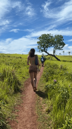 Woman walks barefoot on dirt path in Dapa