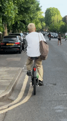 Cyclist rides electric bike through London street