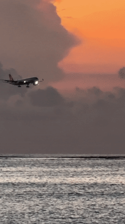 Kuta Beach sunset draws beachgoers, aircraft, ceremonial gathering