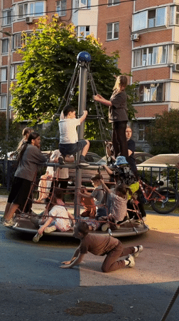 Children play on rope climbing structure at Khimki playground
