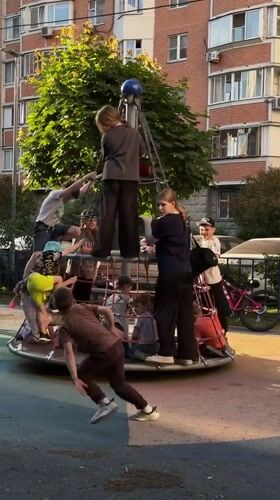 Children play on rope climbing structure at Khimki playground