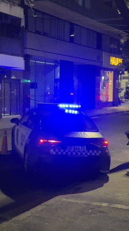 Buenos Aires police car parked at night, lights flashing