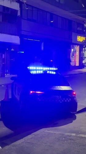 Buenos Aires police car parked at night, lights flashing
