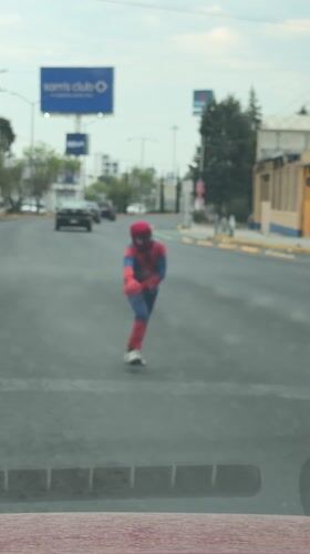 Child in Spider-Man costume performs street handstand in Mexico