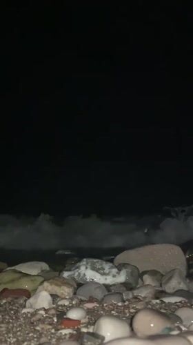 Nighttime waves captured washing over rocky beach near Bar