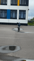 Child cycles through wet streets in Veliky Novgorod