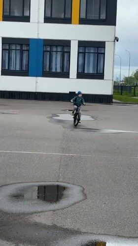Child cycles through wet streets in Veliky Novgorod