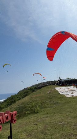 Paragliders take flight over Indonesian coast near Bali
