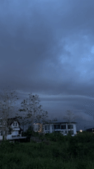 Storm clouds gather over Thai neighborhood in evening documentation