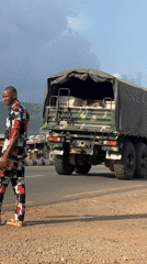 Civilian walks near military truck in Adankolo, Nigeria