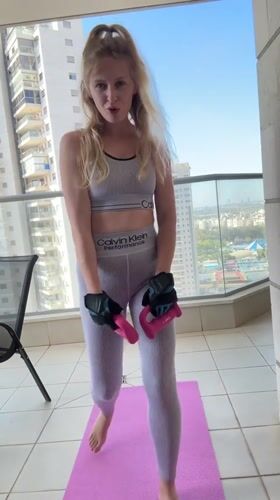 Woman exercises on balcony in Petah Tikva, documents workout
