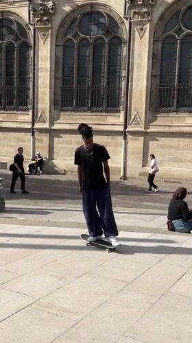 Skateboarder spotted near stone sculpture in Paris plaza