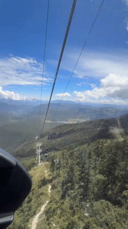 Cable car rides over Yulong's forested and rocky mountain terrain